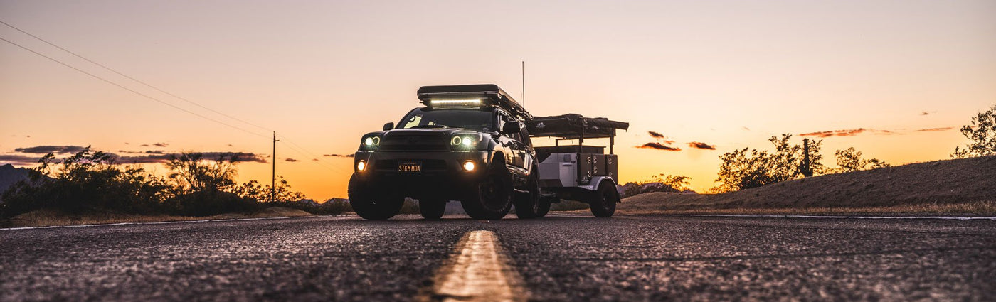 A Tribe Trailer parked in a desert landscape with mountains visible in the background.