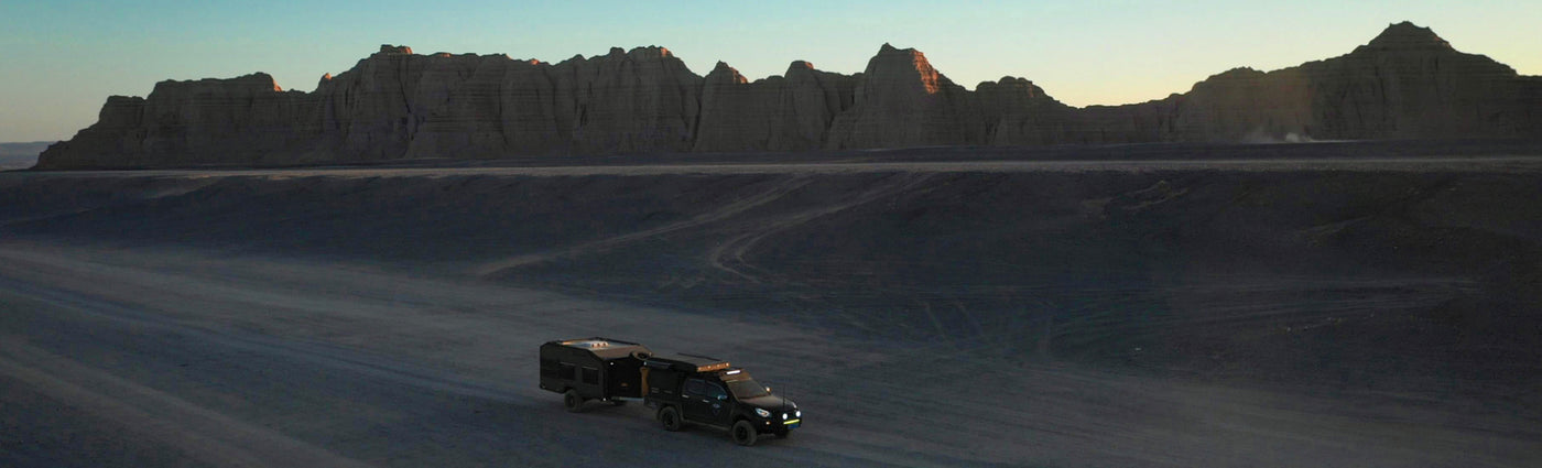 A Tribe Trailer parked in a mountainous area with a body of water visible in the background.